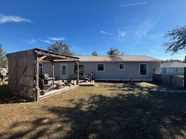 rear view of property with a pergola, a lawn, and a patio