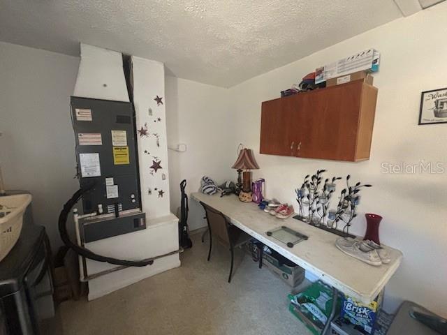 carpeted office featuring a textured ceiling