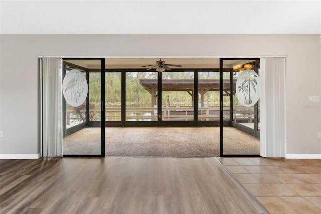 interior space featuring a closet, wood-type flooring, access to outside, and multiple windows