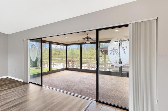 doorway with ceiling fan and hardwood / wood-style floors