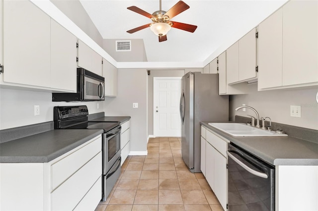 kitchen with appliances with stainless steel finishes, light tile patterned floors, white cabinetry, and sink