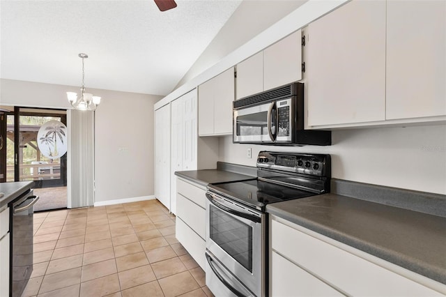 kitchen featuring stainless steel appliances, vaulted ceiling, light tile patterned floors, a chandelier, and white cabinetry