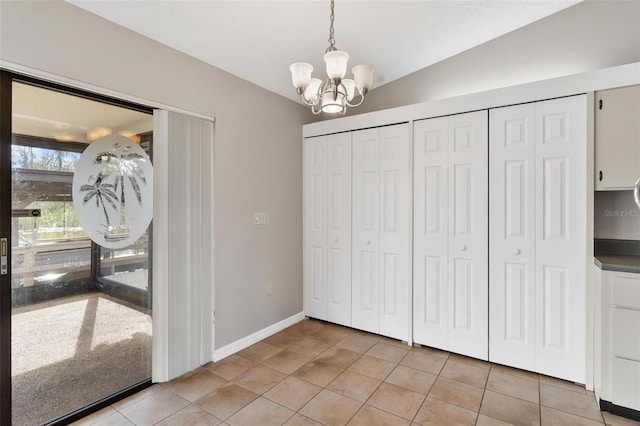 interior space with light tile patterned floors, a chandelier, and vaulted ceiling