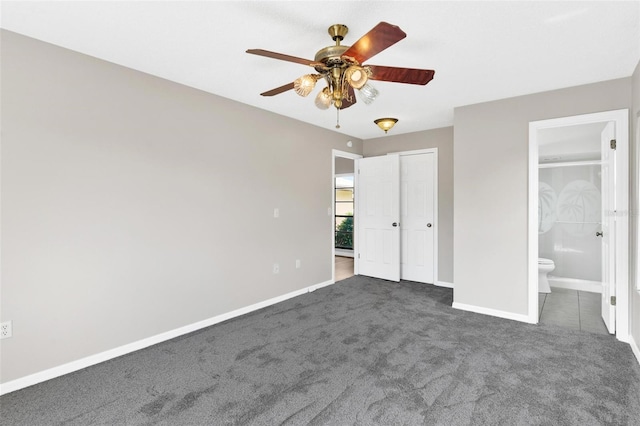 unfurnished bedroom with ensuite bath, ceiling fan, and dark colored carpet