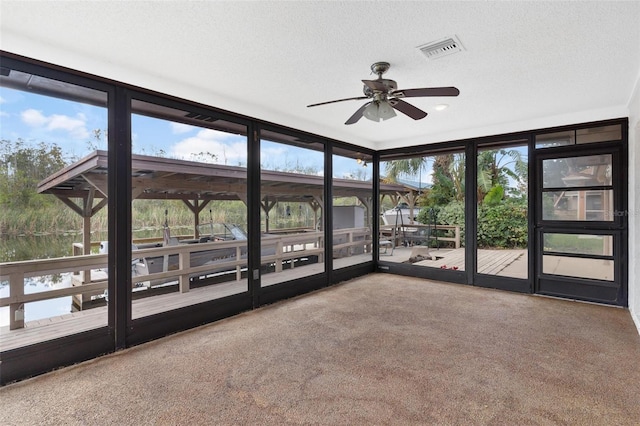 unfurnished sunroom with ceiling fan