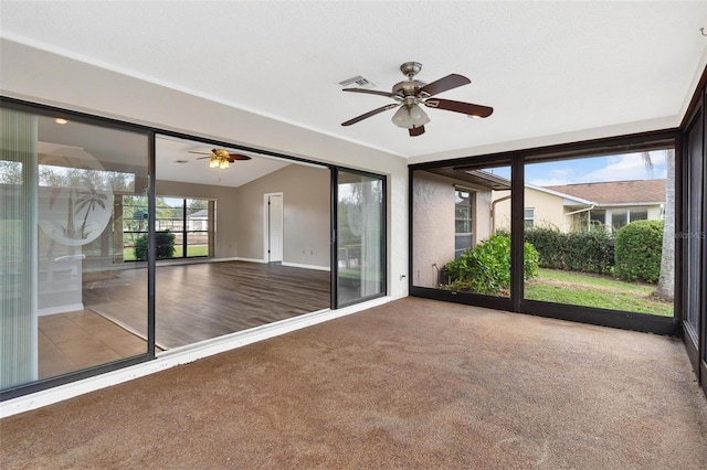 unfurnished sunroom with ceiling fan