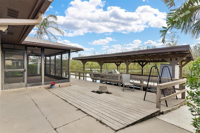 view of patio featuring a deck and a sunroom