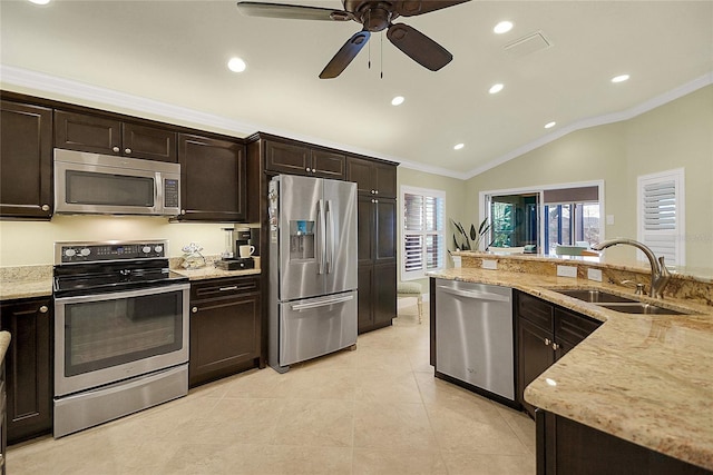 kitchen with light stone countertops, sink, stainless steel appliances, crown molding, and vaulted ceiling