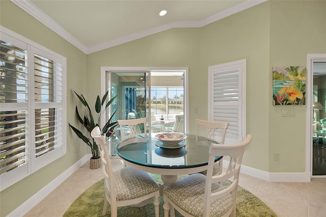 dining space with a wealth of natural light, crown molding, light tile patterned floors, and lofted ceiling