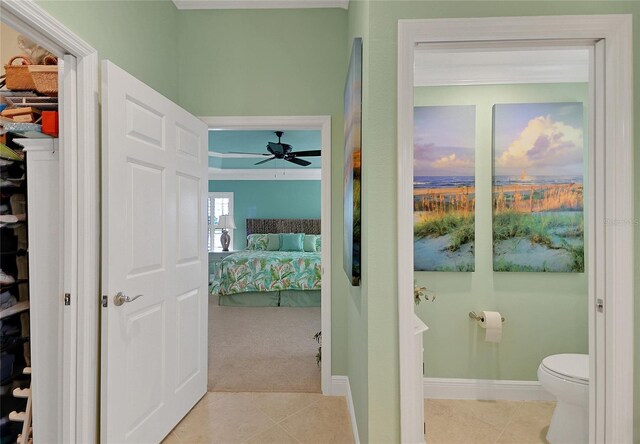 bathroom with toilet, tile patterned floors, ceiling fan, and ornamental molding