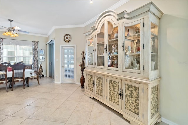 interior space featuring ceiling fan, crown molding, and light tile patterned floors