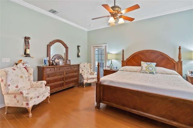 bedroom with ceiling fan, crown molding, and hardwood / wood-style flooring