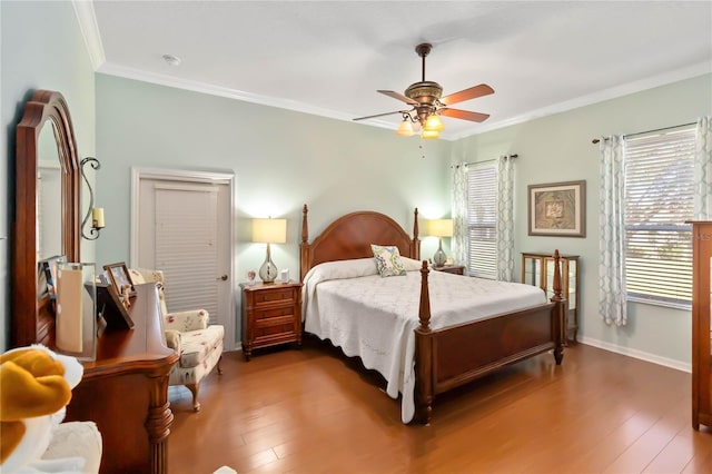 bedroom with dark hardwood / wood-style floors, ceiling fan, and crown molding