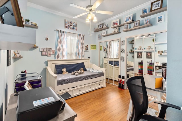 bedroom featuring ceiling fan, wood-type flooring, and ornamental molding