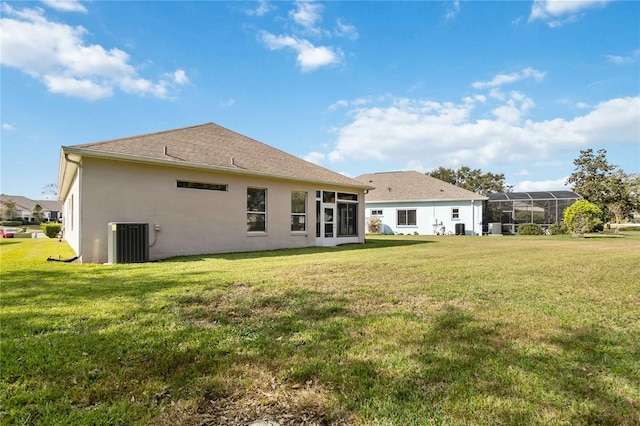 back of property with a lawn and central AC unit