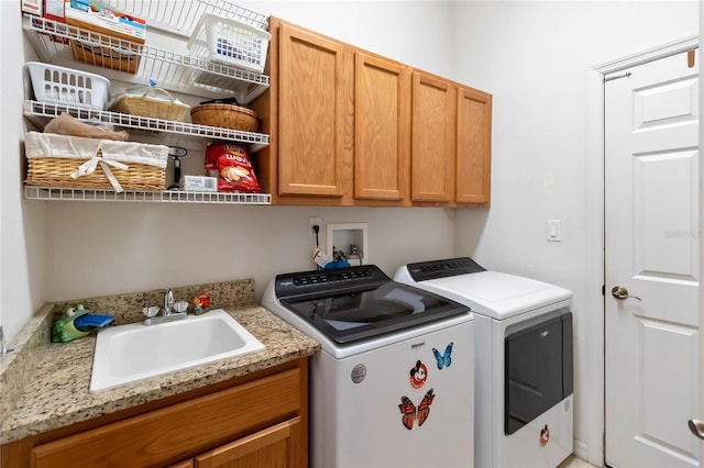 laundry room with washer and dryer, cabinets, and sink