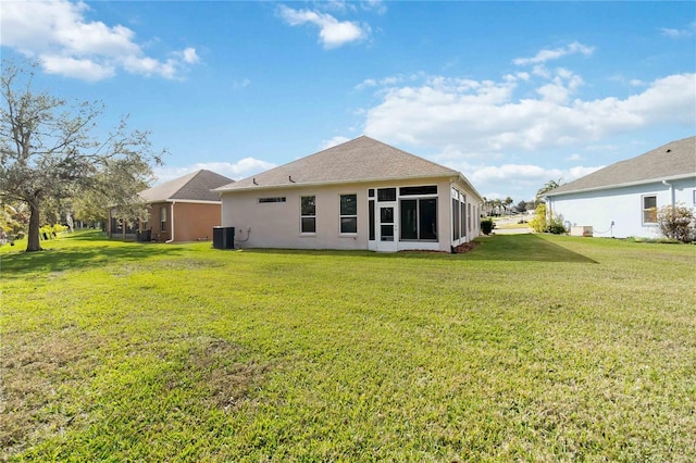 back of property with a yard, cooling unit, and a sunroom