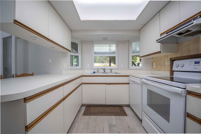 kitchen featuring white cabinets, light wood-style flooring, light countertops, white appliances, and under cabinet range hood