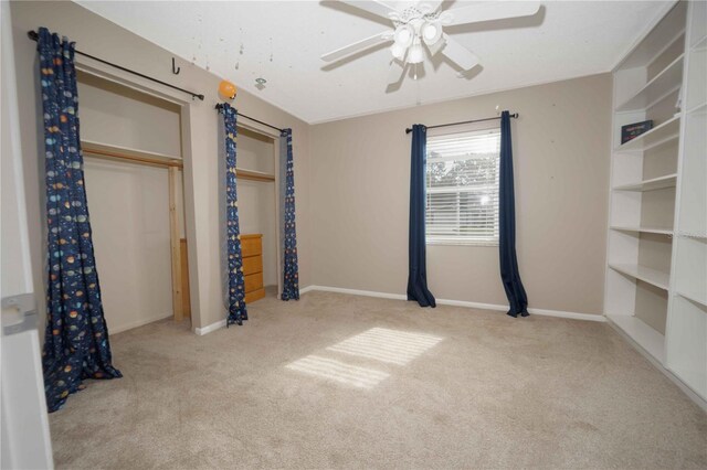 unfurnished bedroom featuring carpet flooring, baseboards, and ceiling fan