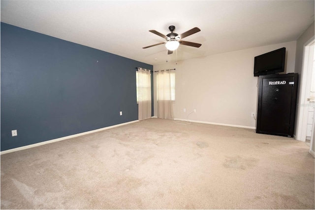 empty room featuring baseboards, ceiling fan, and carpet flooring