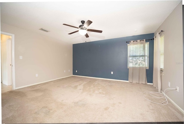 carpeted empty room featuring a ceiling fan, baseboards, and visible vents