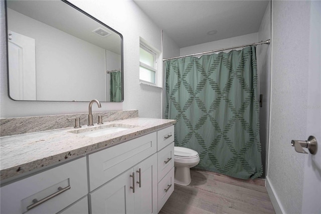 bathroom featuring visible vents, toilet, wood finished floors, curtained shower, and vanity
