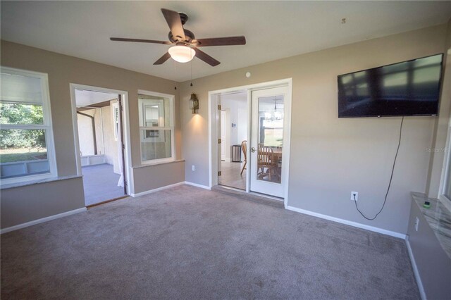 spare room with a ceiling fan, carpet, and baseboards