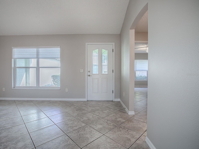 entryway featuring light tile patterned floors and a textured ceiling