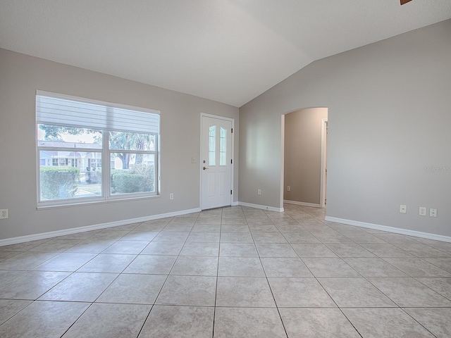 interior space with light tile patterned floors and vaulted ceiling