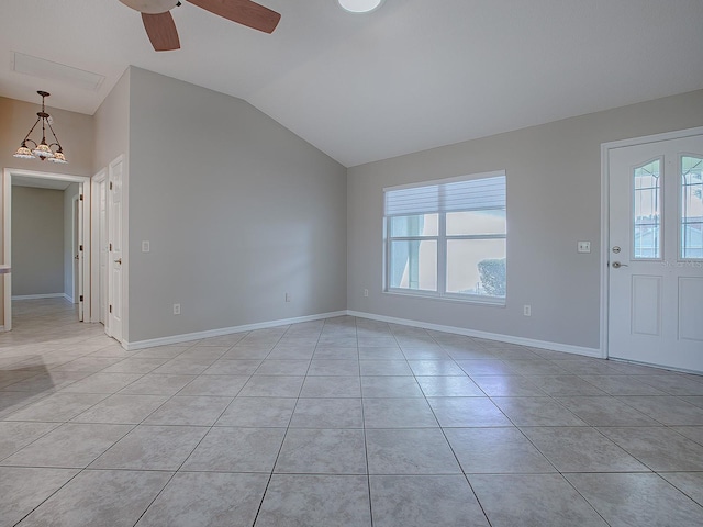 interior space featuring ceiling fan with notable chandelier, light tile patterned floors, a wealth of natural light, and vaulted ceiling