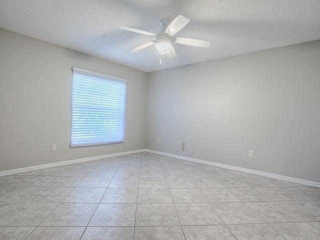 spare room with light tile patterned floors, a textured ceiling, and ceiling fan