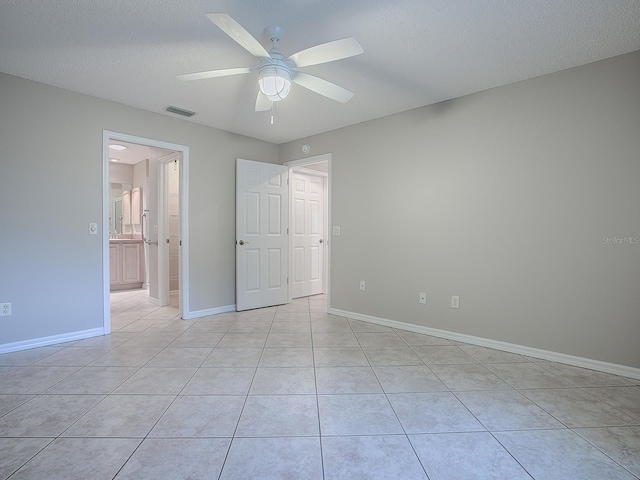 unfurnished bedroom featuring ceiling fan, light tile patterned flooring, and a textured ceiling