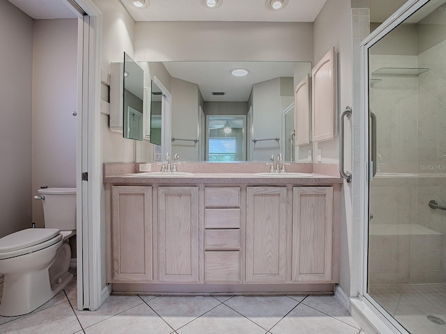 bathroom with tile patterned floors, a shower with shower door, and toilet