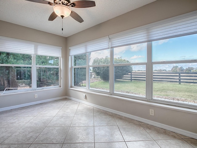 unfurnished sunroom featuring ceiling fan