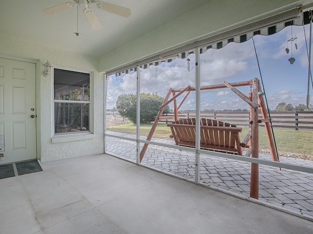 unfurnished sunroom with ceiling fan