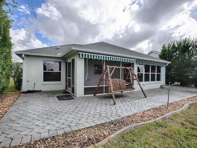 back of property with a patio area and a sunroom