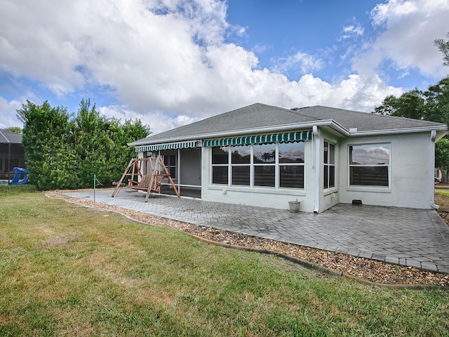 rear view of property featuring a lawn and a patio