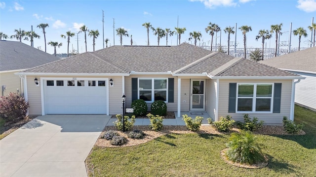 single story home featuring a garage, a shingled roof, concrete driveway, and a front yard