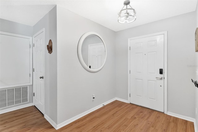 foyer featuring hardwood / wood-style floors and a notable chandelier