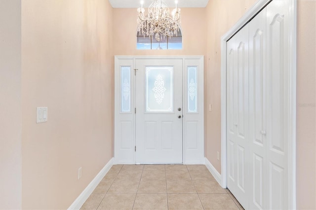 tiled entryway with a chandelier