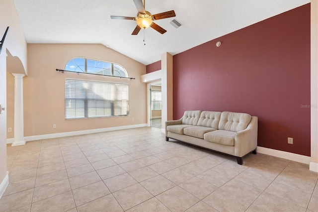 unfurnished living room featuring decorative columns, ceiling fan, light tile patterned floors, and vaulted ceiling