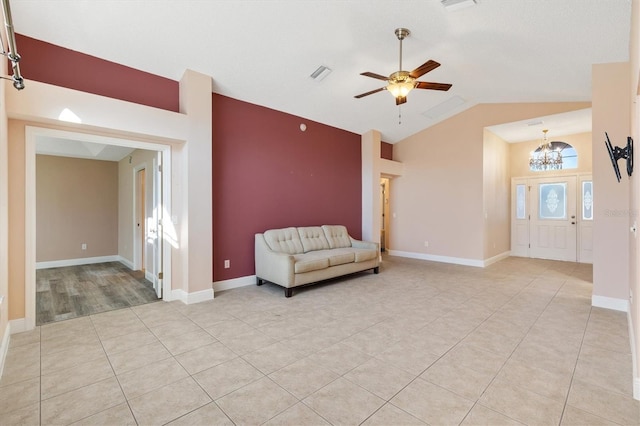 unfurnished room featuring ceiling fan with notable chandelier, light tile patterned flooring, and lofted ceiling