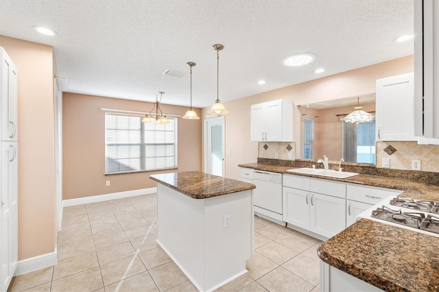 kitchen with dishwasher, a kitchen island, and white cabinetry