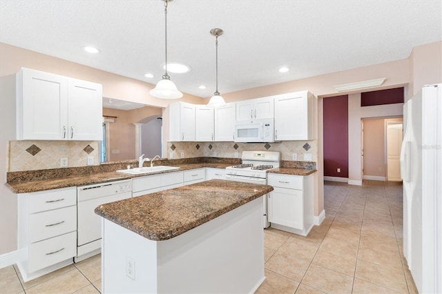 kitchen featuring sink, a kitchen island, decorative light fixtures, white appliances, and white cabinets