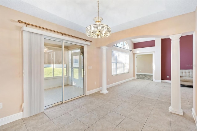 tiled empty room with a notable chandelier and decorative columns