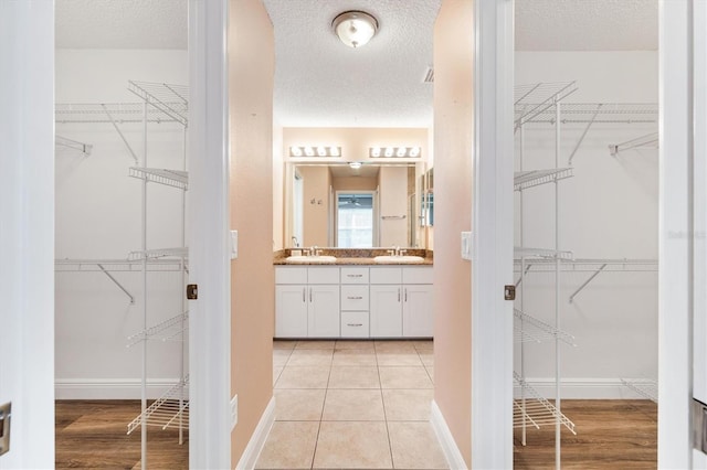 bathroom featuring tile patterned flooring, a textured ceiling, and vanity