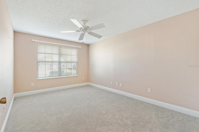 carpeted empty room featuring ceiling fan and a textured ceiling