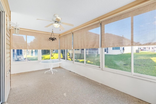 unfurnished sunroom with ceiling fan