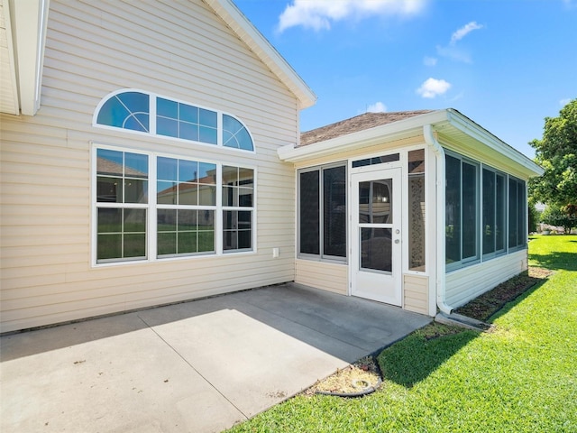 exterior space featuring a sunroom, a patio area, and a lawn