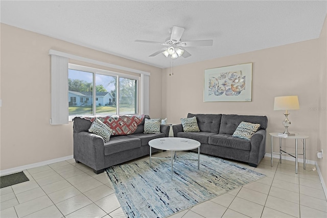 living room featuring light tile patterned floors, a textured ceiling, and ceiling fan